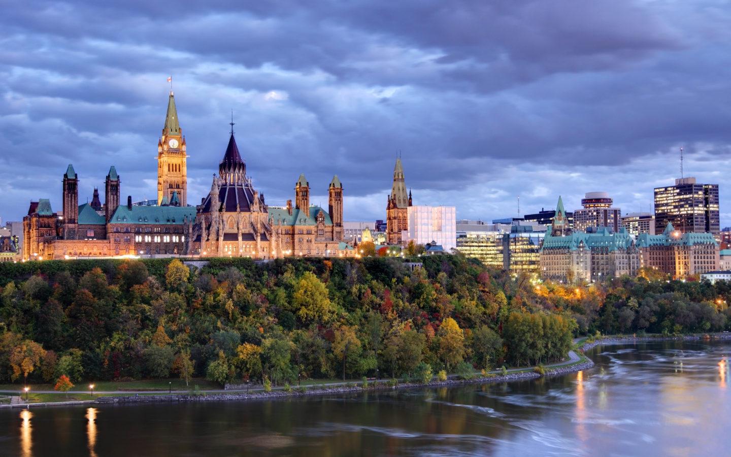 Parliament Hill atop a dramatic hill overlooking the Ottawa River in Ottawa, Ontario in autumn. Parliament Hill is home to Canada's federal government and is the centrepiece of Ottawa’s downtown landscape. Ottawa is known for is high-tech business sector, vast array of museums and high standard of living.