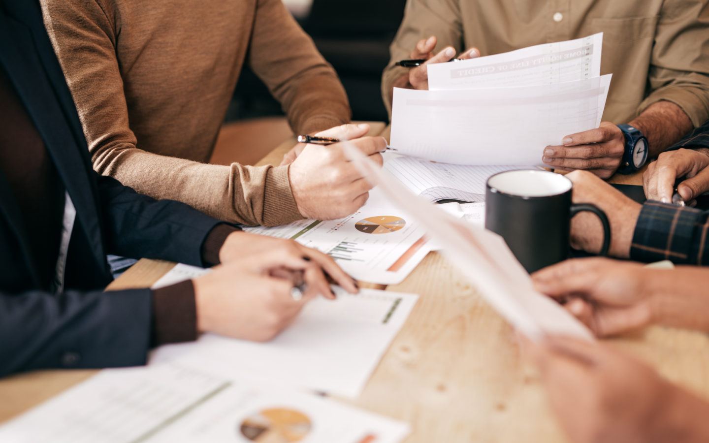 men and women in a meeting going over paperwork